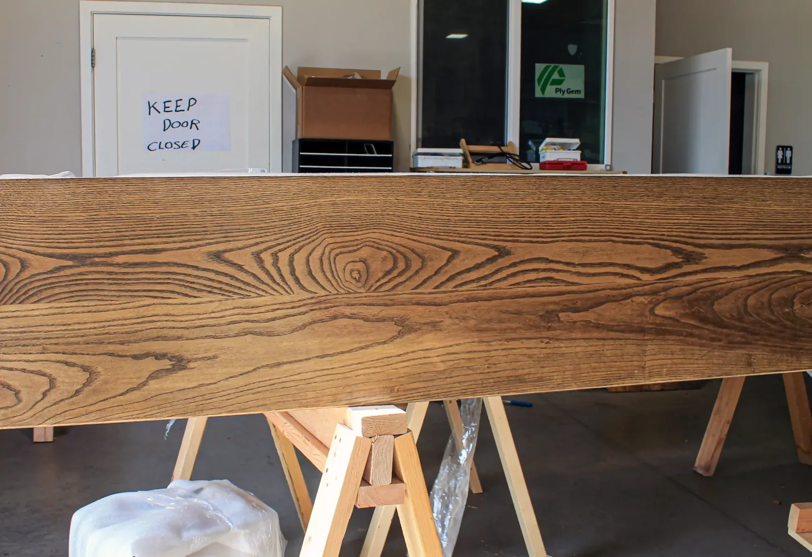 Wide milled board with deep grain texture resting on sawhorses in the shop