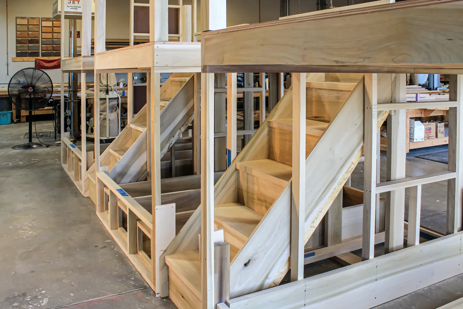 Unfinished wood stair and railing assemblies built in the shop