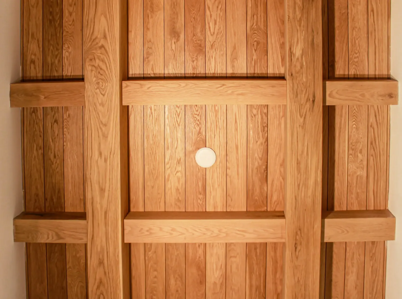 Ceiling clad in narrow wood planks framed by a grid of wood beams