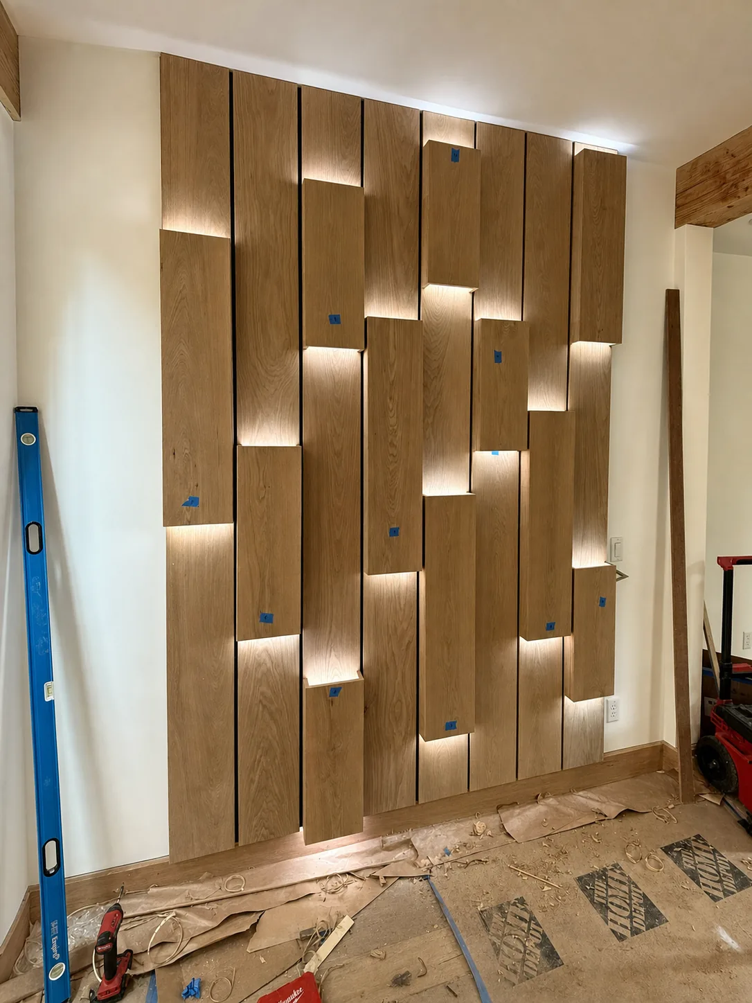 Installed accent wall of staggered vertical panels with light washing down the face of each panel