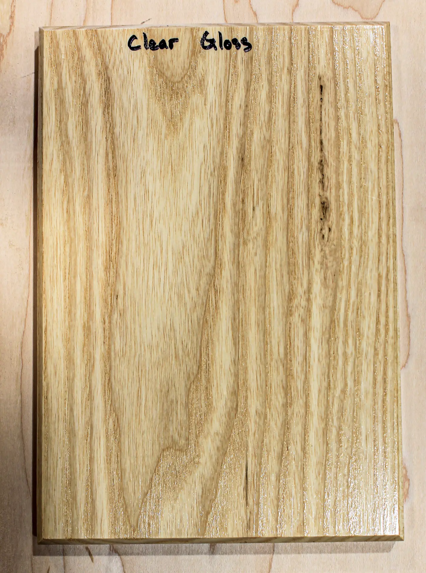 Finish sample board with a high-sheen clear topcoat, hand labeled "Clear Gloss"