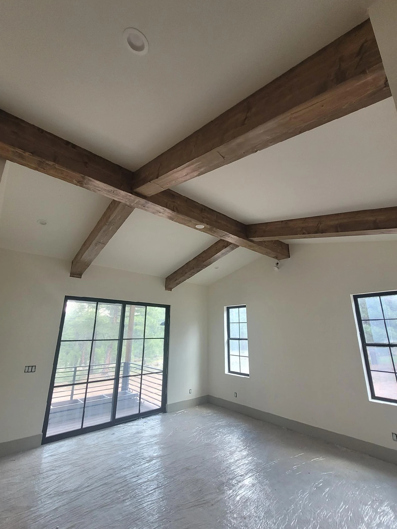 Finished great room with hand-hewn pine ceiling beams by Tier 1 HomeWorx