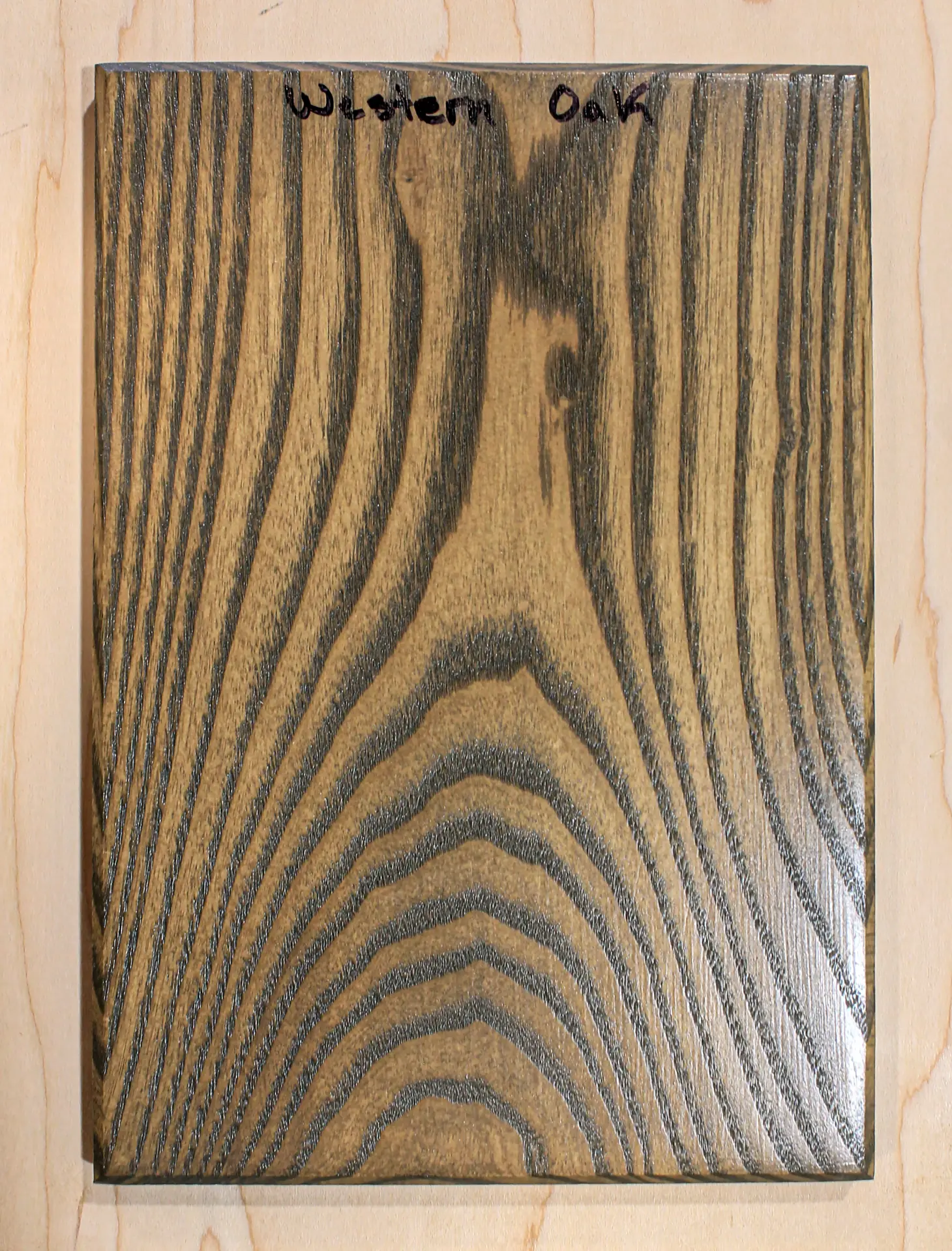 Finish sample board in a mid-brown stain with strongly darkened grain lines, hand labeled "Western Oak"