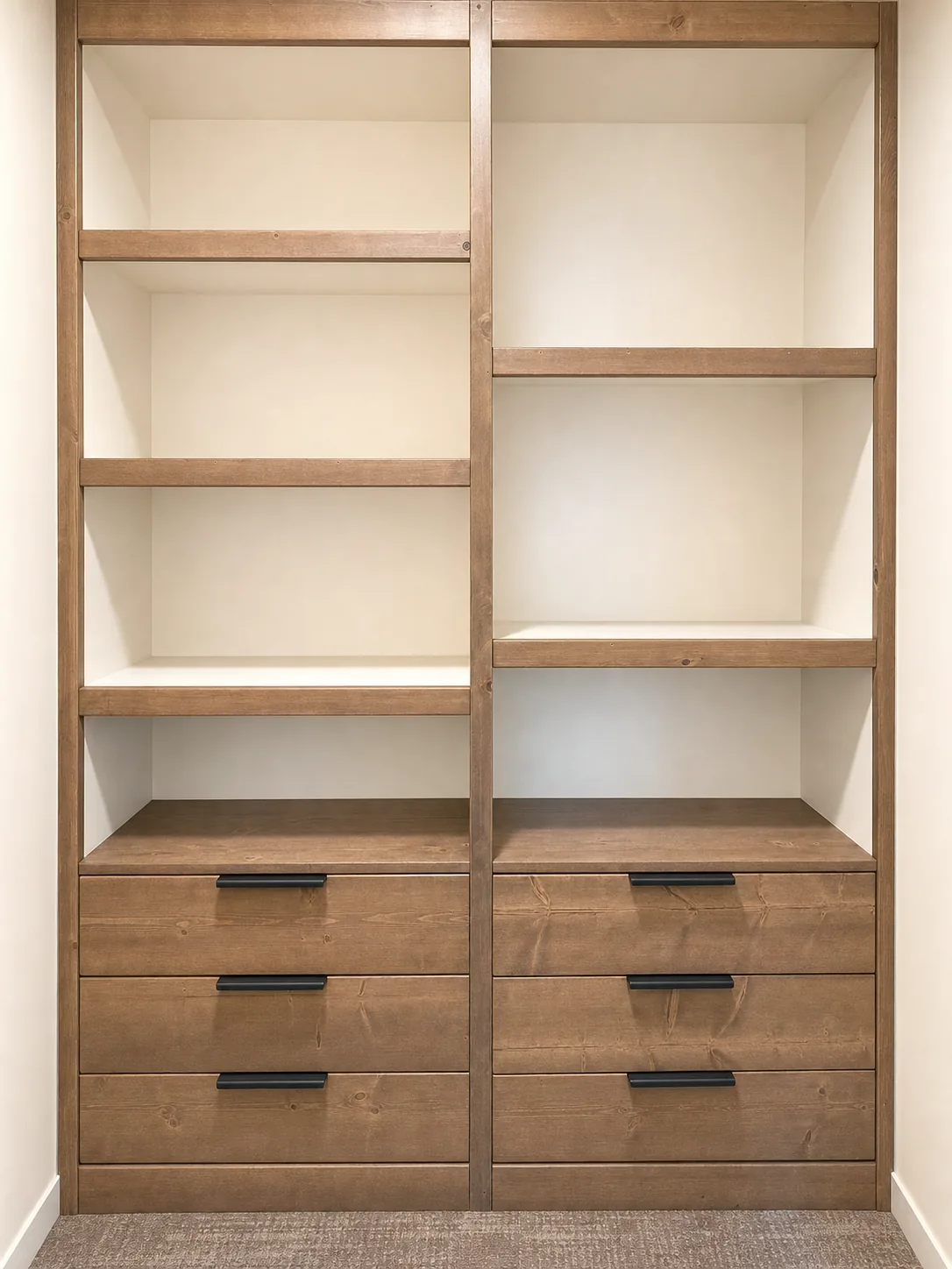 Closet built-in with open shelving and two three-drawer banks with black pulls